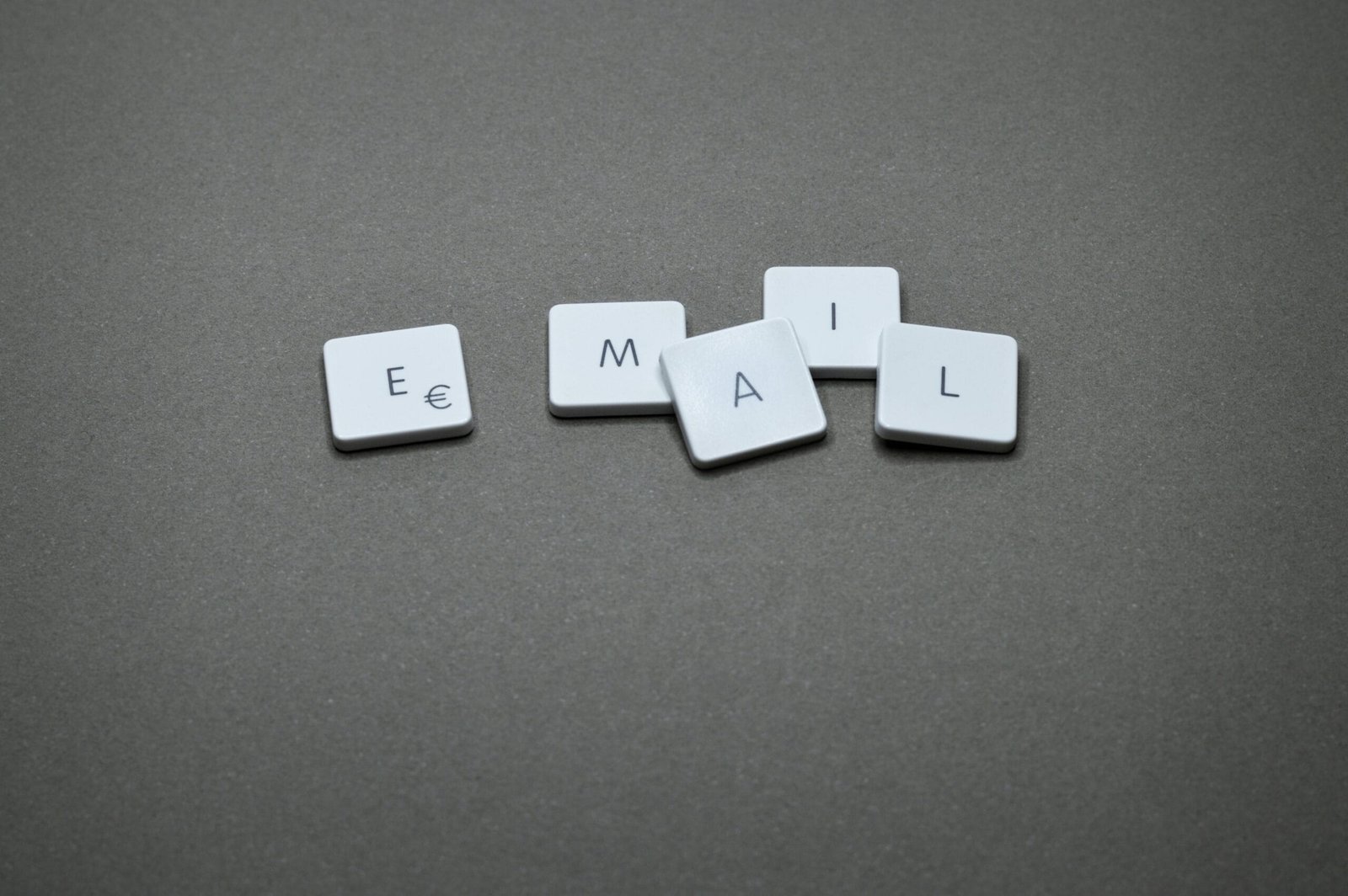 Close-up of the word 'email' formed with letter tiles on a gray surface.Gros plan du mot « e-mail » formé de carreaux de lettres sur une surface grise.